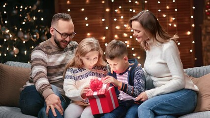 Adorable family opening fairytale wrapped red Xmas gift box together. Shot with RED camera in 4K - Powered by Adobe