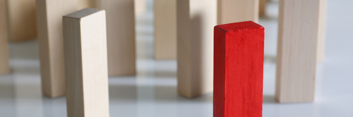 Close up of domino wood blocks with volunteer ahead the crowd standing on white surface