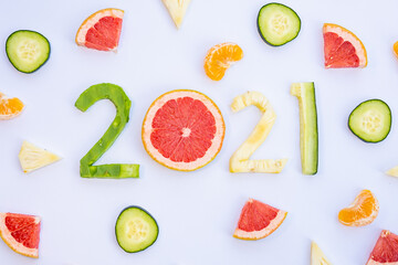 Exquisite fruits cut in the shape of the new year 2021 on a white table.