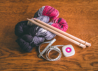 Supplies for a new hobby: wooden knitting needles, handspun yarn, and measuring tape displayed on a...