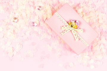 Pink gift box full of tender pink hearts of confetti on pastel background. Valentine's Day, wedding, love concept. Top view, flat lay, copy space.