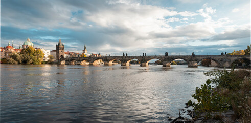 .panorama of Charles bridge over Vltava river and blue sky at sunset in the center of Prague and Vltava river during the day