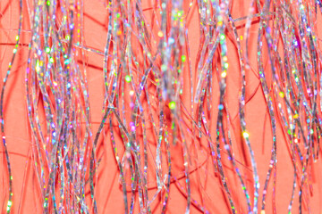 festive holographic tinsel fringe detail on coral red background