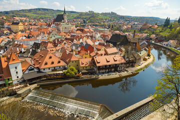 Beautiful city on the river Bank, houses with red tile roofs. River around the town. Picturesque place. Sight.