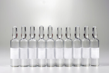 Row of medical ampoules with medicine, on a gray background. Vaccination and Immunization. Health...