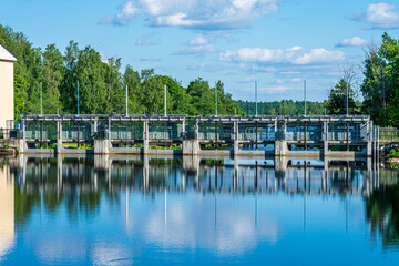 Fototapeta na wymiar Summer view of the dam with water gates of a hydroelectric power plant in Sweden