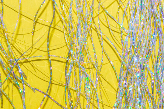 Silver Holographic Tinsel Fringe On An Illuminating Yellow Background