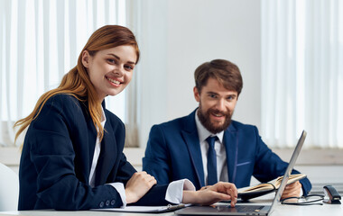 Happy Business people in the office with a laptop are sitting at the table In a bright room