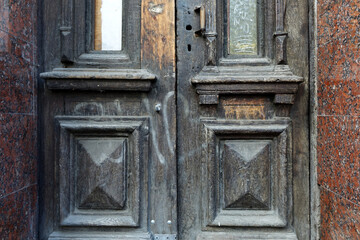 Wood texture of vintage entrance door to a house lined with granite