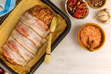 Freshly prepared meatloaf ready for the oven with ingredients. Minced meat with chili spices and sausage. Making classic meatloaf with ground beef.