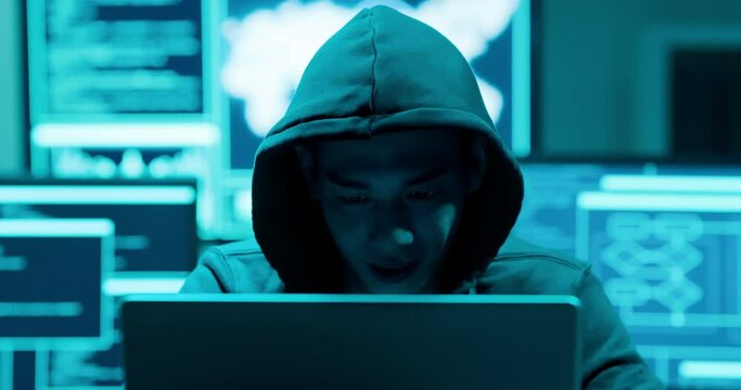 Asian male hacker use laptop