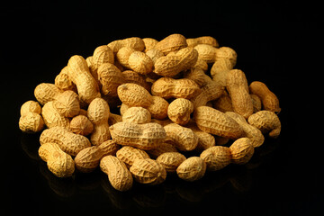 Peanuts in shell on a black background. Top view. Copy, empty space for text