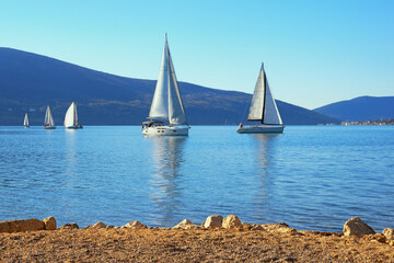 Winter Mediterranean landscape with sailing boats on water. Montenegro. View of Bay of Kotor near Tivat city