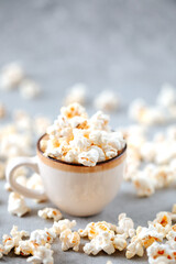 Homemade popcorn in a ceramic bowl on a grey background