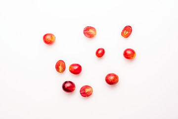 whole and cut red grapes on white background