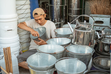 craftsman installing the bucket handle while sitting in a homeware store