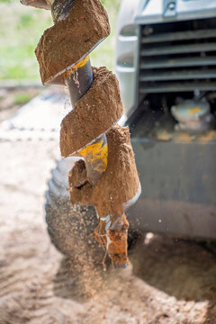 A Mechanical Auger Digging A Post Hole