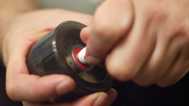 Close up of person repairing a roller skate wheel on a retro pair of rollerskates