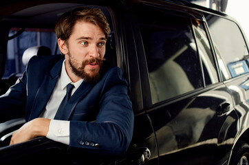 business man in suit driving car in showroom and emotions model