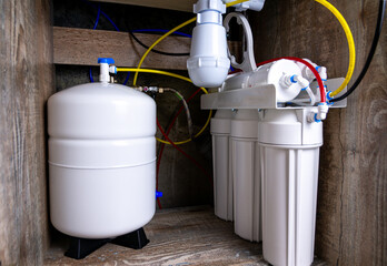 Installing a five-stage water filter under the sink in the kitchen