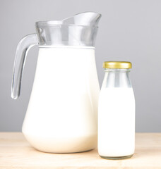 jug and bottle of fresh milk glass on wooden table background.  .Raw milk is high in calcium and protein to drink for all ages..Milk consumption nutritious and healthy dairy products concept.