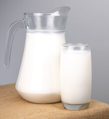 A jug of fresh milk glass on sackcloth for a background..Raw milk is high in calcium and protein to drink for all ages..Milk consumption nutritious and healthy dairy products concept.