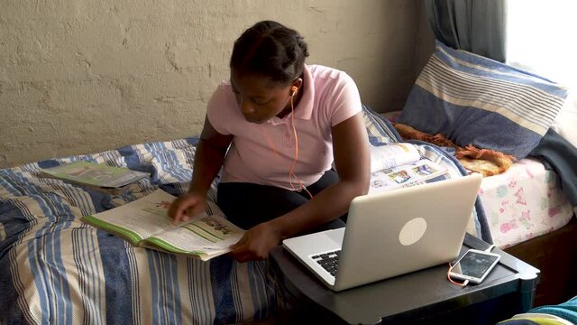 Young Black African girl busy with home schooling during lockdown for Covid-19 Coronavirus pandemic, South Africa