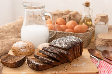 Homemade chicken eggs and freshly baked bread on a wooden table.