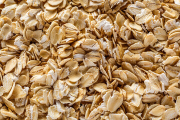 Background of oatmeal. Daylight. Throughout the frame are oatmeal flakes.Diet food concept.Top view