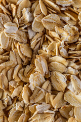Background of oatmeal. Daylight. Throughout the frame are oatmeal flakes.Diet food concept.Top view