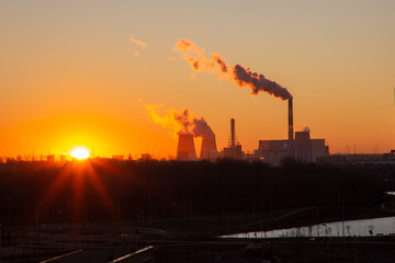 View of the beautiful sunrise over the pipes of the electric power station. Yuzhnaya Thermal Power Plant Saint Petersburg Russia. Smoke from chimneys.