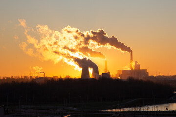 View of the beautiful sunrise over the pipes of the electric power station. Yuzhnaya Thermal Power Plant Saint Petersburg Russia. Smoke from chimneys.