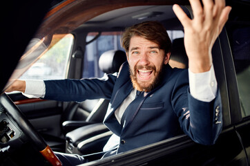 aggressive business man looking out of the car window and gesturing with his hands