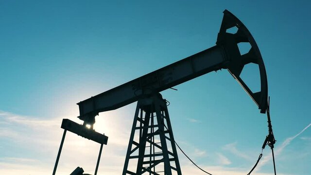 Closeup of oil pumpjack at oil field on a sunny day