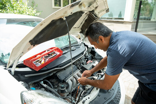 Man Fixing Car With Hood Up