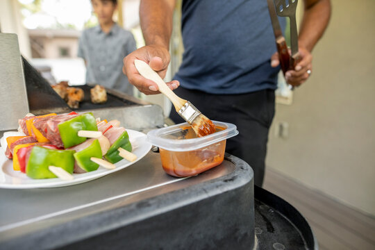 Close up of man scooping barbecue sauce from container