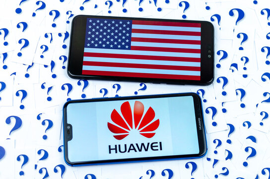 HUAWEI logo and American flag on the smartphones and a lot of cut paper question marks around. The conceptual photo about future of HUAWEI in the US.