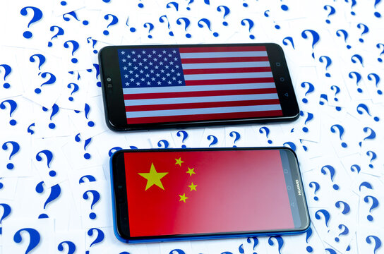 Flag of America and China on the Huawei smartphones and a lot of question marks around. The conceptual photo about future of the US China relationship