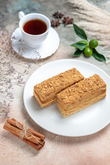 front view tasty cake slices with tea on a light background sweet cake pie biscuits