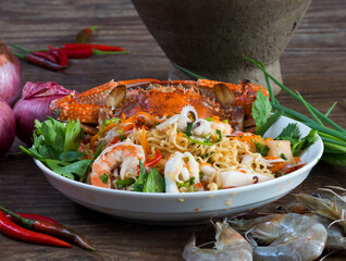 Thai spicy seafood salad with shrimps, squid, crab and steamed fish