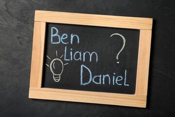 Obraz premium Blackboard with baby names on black stone table, top view