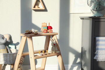 Stylish wooden ladder in baby room interior