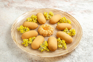 a sideline photo of one plate of tasty cookies on a white marble background