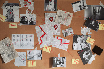 Detective board with crime scene photos and red threads, closeup