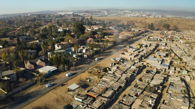 Inequality.Aerial panning view of an informal settlement Kya Sands squatter camp right next to middle class suburban housing, Gauteng Province, South Africa