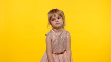 Bored tired lazy child looking at camera with indifference, shocked and dissatisfied from something, not interested in communication. Little blonde kid girl 5-6 years old posing on yellow background
