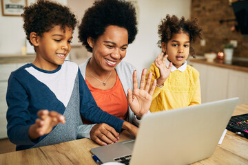 Happy African American family having video call over laptop at home.