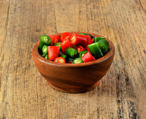 slice green hot chili  in wooden cup on wood table