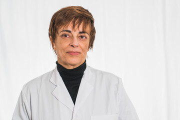 Smiling doctor in lab coat with arms crossed on a white background