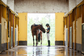 Young women stroked the horse stables door